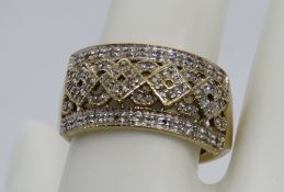 A 9ct gold ring encrusted with white stones in a geometric pattern, size W, hallmarked 375, 4.5g.