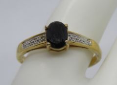 A yellow metal ring set with dark blue semi-precious gemstone, no hallmarks, for reshaping.