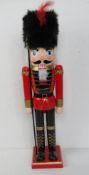 A contemporary painted wooden Nutcracker figurine standing 61cm high.