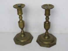 A pair of brass candlesticks having once been converted for use as lamps.