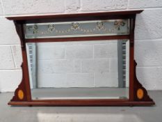 A delightful Edwardian wall mirror having inlaid and coloured decoration to glass and frame.