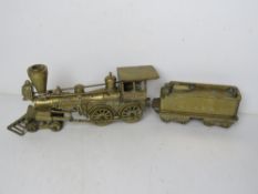 A large and heavy brass model train having articulated wheels marked for 
