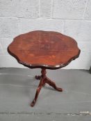 An occosional table having inlaid pattern to shaped top over three outswept legs.