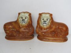 A pair of Staffordshire Lions with glass eyes each 28cm wide.