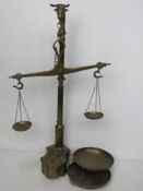 A brass set of balance scales with weights having bulls head finial and standing 59cm high.