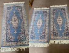 Three (2+1) matching Royal Keshan 100% wool rugs, in blue ground, one measuring 83 x 160cm,