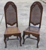 A pair of finely carved oak chairs with cane work seats (one restored, one a/f).