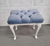 A dressing table stool upholstered in blue velour fabric.