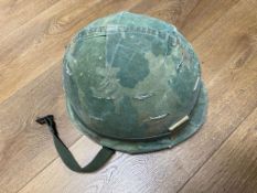 A US Vietnam M1 helmet with foliage band, matches and big roll, dated 68/69. This lot will be
