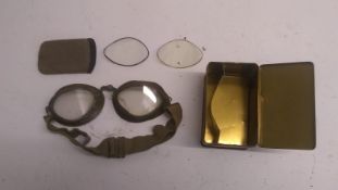 A WWII Germen Luftwaffe Model 306 flying goggles with tin and replacement lenses in bag. This lot