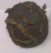 A reproduction WWII German Paratrooper helmet with camo netting.