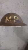 A WWII British Military Police helmet with period cartoon decals upon.