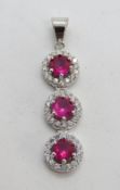 A silver pendant set with red and white stones, stamped 925, approx 4cm in length.