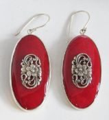 A large pair of silver and red stone earrings having art nouveau style floral panel to centre,