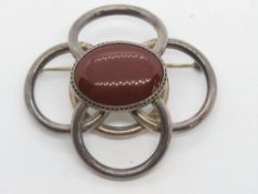 A large silver brooch having central carnelian cabachon, stamped 925 with Russian? hallmark over, 6.