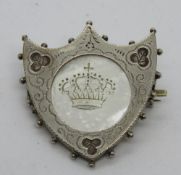 A hallmarked silver brooch in the form of a shield having central mother of pearl panel and clover