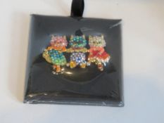 A Butler & Wilson 'Three Happy Cats' crystal brooch in original packet.