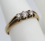 A 9ct gold ring having carved head set with three graduated round cut white cz stones,