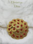A vintage Christian Dior brooch, on original silken pad, 1970s disc design with red beads upon,