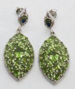 A large pair of peridot encrusted silver earrings, stamped 925, with butterfly backs, 6.