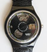 An automatic Swatch watch in Black Motion pattern, within original packaging.