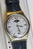 A Swatch watch in Moon Phase pattern, original packaging, new battery within box.