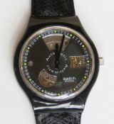 An automatic Swatch watch in Black Motion pattern, within original packaging.