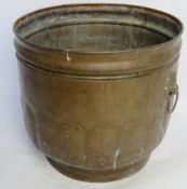A copper coal bucker with lion head handles.