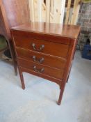 A three drawer mahogany music cabinet.