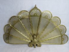 A brass peacock tail fireguard.