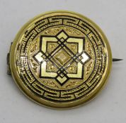An early 20th century yellow metal brooch with black enamel inlay,