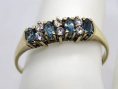 A 9ct gold and aquamarine ring, the four oval cut stones separated by three pairs of white stones,