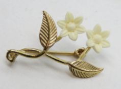 A 9ct gold floral brooch, white celluloid flowers, hallmarked 375, 2.8cm high.