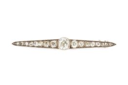 A diamond bar brooch, designed as a line of graduated cushion-shaped old-cut diamonds in