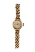 A lady's 9ct gold bracelet watch by Accurist, the circular silvered dial with gilt baton markers, to
