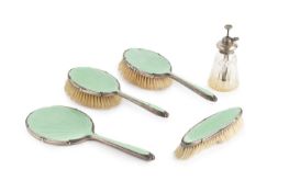 A silver and green enamel backed dressing table set, comprising hand mirror, two hair brushes and