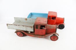 Two vintage tinplate tipper-trucks.