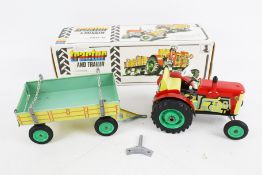 A vintage KDN clockwork tractor and trailer.