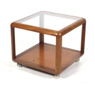 A mid-century teak and glass top coffee table. With a shelf beneath on chrome feet.