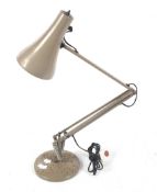 An angelpoise desk lamp with circular base.