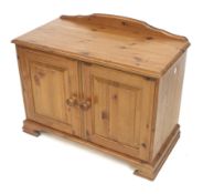 A contemporary pine cupboard. With two doors on bracket feet.