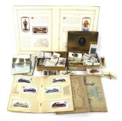 An assortment of cigarette cards and postcards.