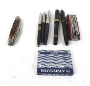 A collection of Parker pens and two penknives.