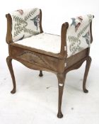 A piano stool with scroll arms, raised on cabriole supports.