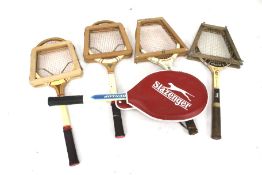 A collection of sports equipment. Including tennis rackets, a cricket bat, etc.