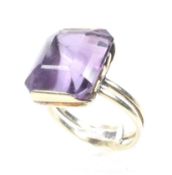 A vintage gold and amethyst single stone ring. The cut-corner rectangular step-cut amethyst approx.