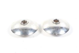 Local interest, a pair of silver compressed round candle or taper sticks.