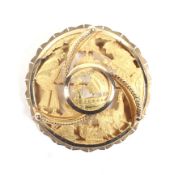 A South American shaped-round, pierced and engraved brooch depicting a llama and figures.