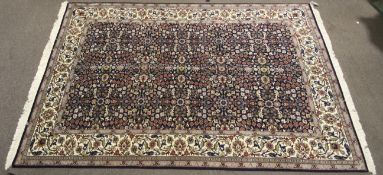 A Hereke Yun hand made rug of wool on cotton comprising of a cream center ground with flowers