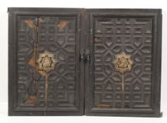 A pair of circa 1900 medieval ? carved masks affixed to a pair of oak doors.